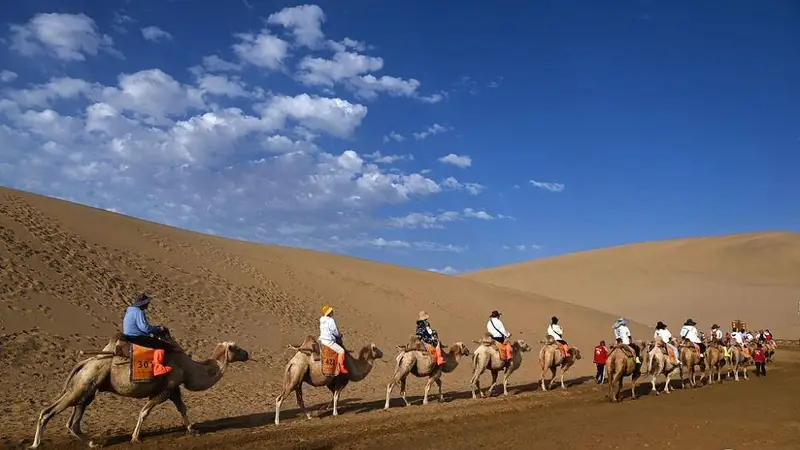 甘肃敦煌游人畅玩鸣沙山月牙泉 体验“大漠驼铃响”