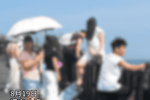 多位游客翻越滨海东路护栏，站在悬崖上拍照打卡