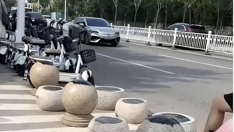 日照一海水浴场门口隔离石墩被涂抹沥青,游客带娃经过鞋和身上都粘上