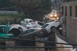 山西吕梁一路口多辆私家车堆叠，市民：车随水而下堆积，不少人来寻车